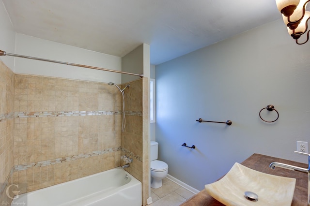 bathroom with toilet, a sink, bathing tub / shower combination, baseboards, and tile patterned floors