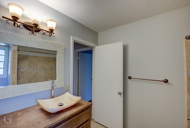 bathroom with tiled shower and vanity