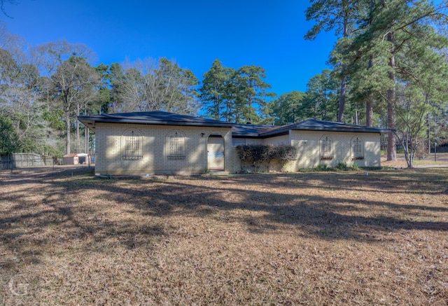 view of front of house featuring brick siding and a front lawn