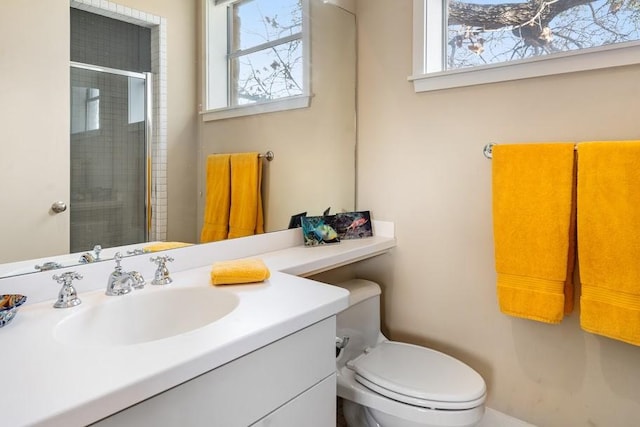 full bath featuring toilet, plenty of natural light, a tile shower, and vanity