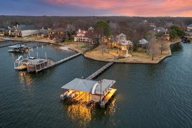 dock area with a water view, boat lift, and a residential view