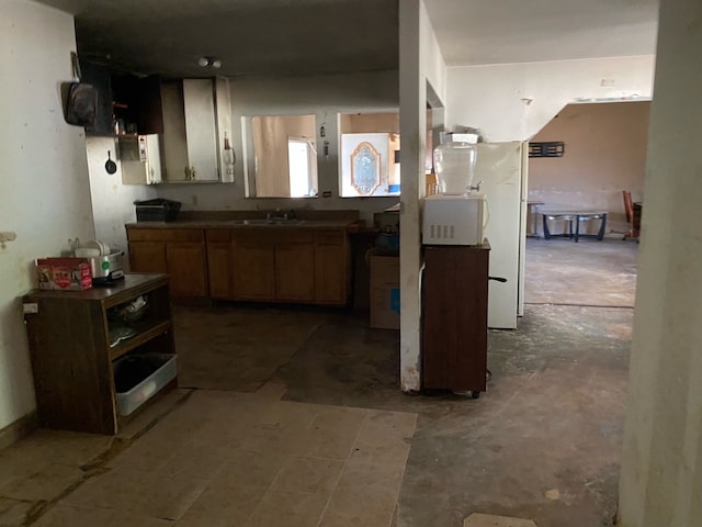 kitchen with freestanding refrigerator and a sink