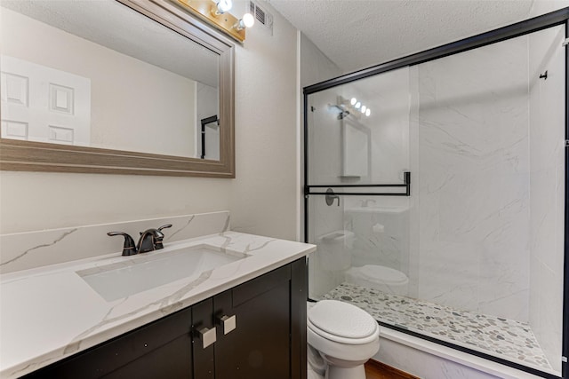 full bath with a textured ceiling, toilet, visible vents, vanity, and a stall shower