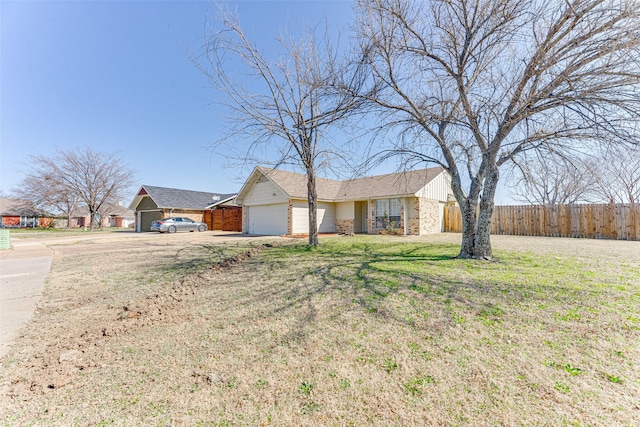 ranch-style home with an attached garage, fence, and a front lawn