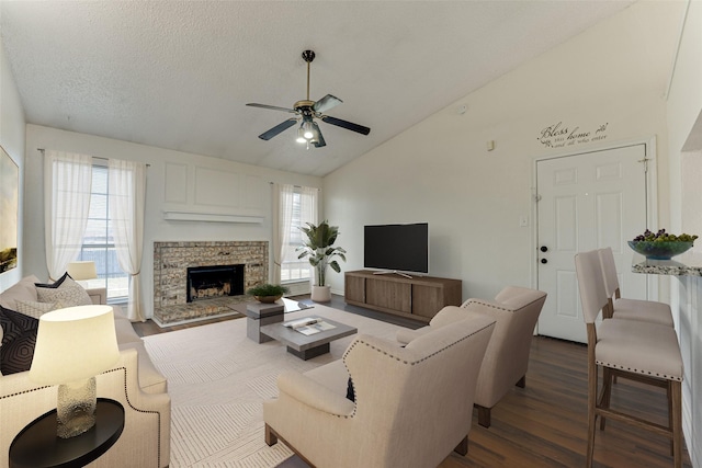 living room featuring a textured ceiling, dark wood finished floors, a ceiling fan, and a healthy amount of sunlight