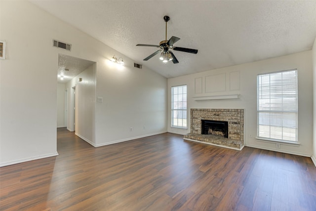 unfurnished living room featuring dark wood-type flooring, lofted ceiling, visible vents, and a textured ceiling