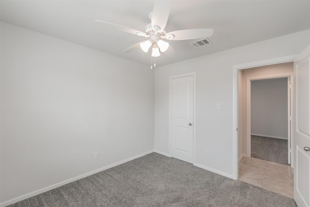 unfurnished room with baseboards, carpet flooring, visible vents, and a ceiling fan