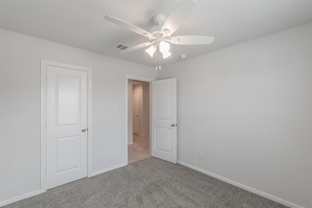 unfurnished bedroom with carpet floors, visible vents, baseboards, and a ceiling fan