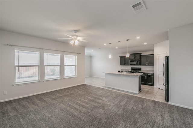 kitchen with black microwave, visible vents, open floor plan, and gas range