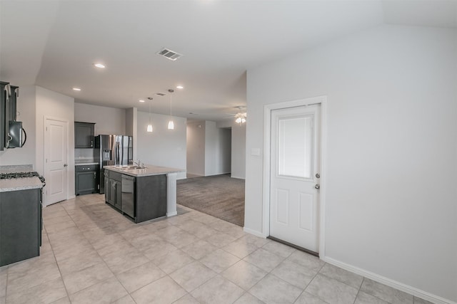 kitchen with black microwave, dishwashing machine, visible vents, hanging light fixtures, and a center island with sink