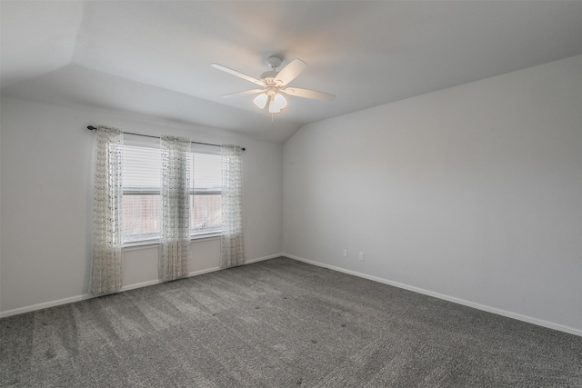 carpeted spare room featuring vaulted ceiling, baseboards, and ceiling fan