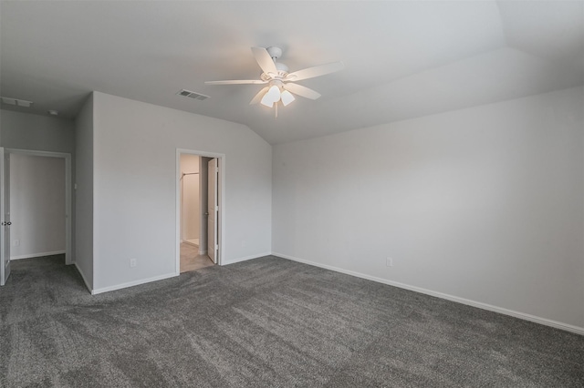 unfurnished bedroom featuring dark carpet, baseboards, visible vents, and vaulted ceiling