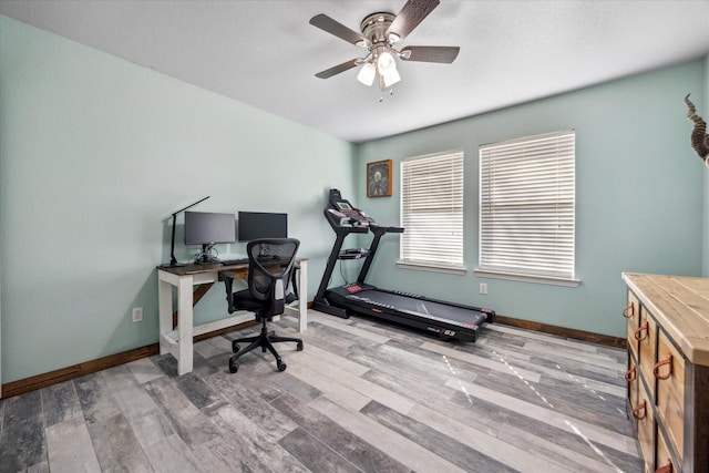 office area with a ceiling fan, baseboards, and wood finished floors