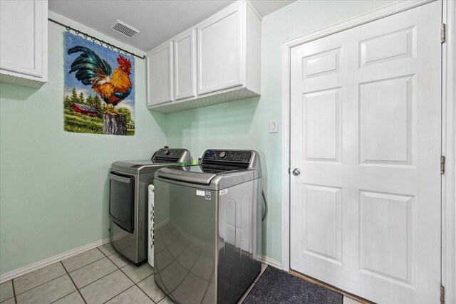 laundry room featuring light tile patterned floors, visible vents, baseboards, washer and dryer, and cabinet space