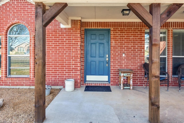 entrance to property featuring brick siding