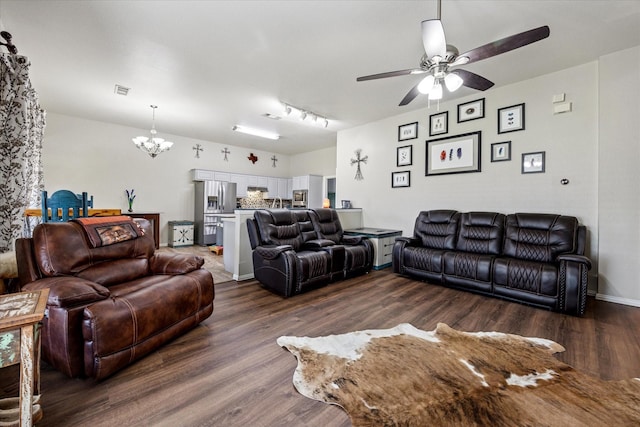 living room with baseboards, visible vents, dark wood-type flooring, and ceiling fan with notable chandelier