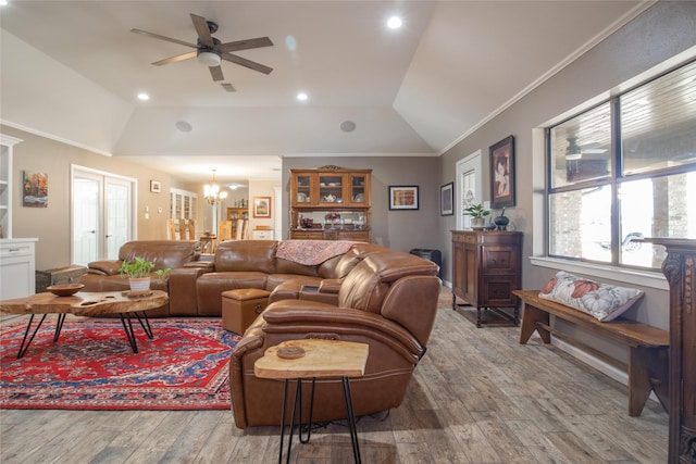 living room featuring lofted ceiling, ornamental molding, wood finished floors, ceiling fan with notable chandelier, and recessed lighting