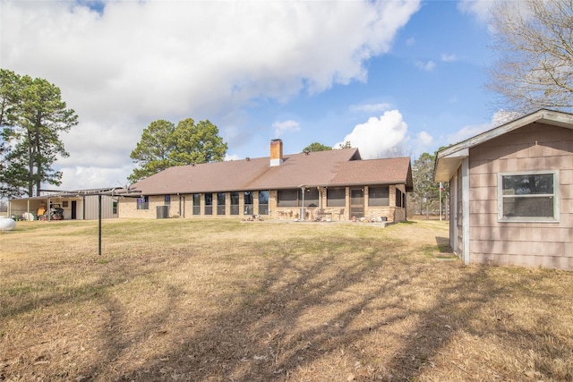 back of property featuring a lawn and a chimney