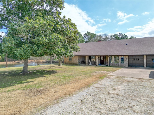 view of front facade with a garage, brick siding, concrete driveway, and a front yard