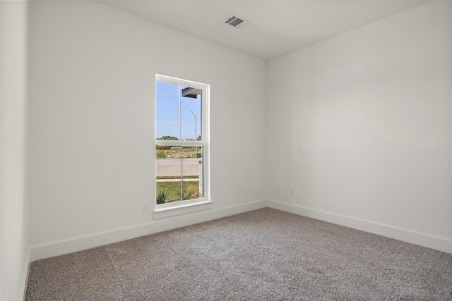 spare room featuring carpet floors, baseboards, and visible vents