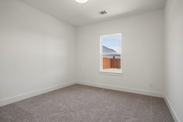 empty room featuring baseboards, visible vents, and light colored carpet