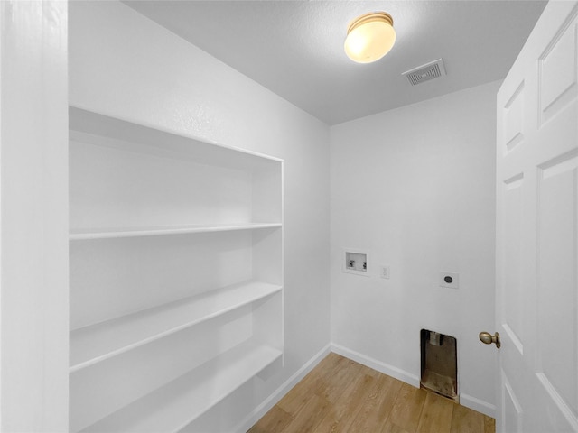 clothes washing area with washer hookup, visible vents, hookup for an electric dryer, wood finished floors, and laundry area