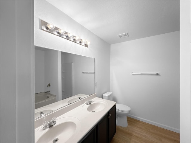 full bath featuring visible vents, a sink, toilet, and wood finished floors