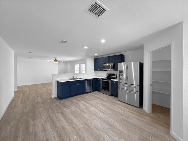 kitchen featuring stainless steel appliances, light countertops, visible vents, blue cabinets, and a peninsula