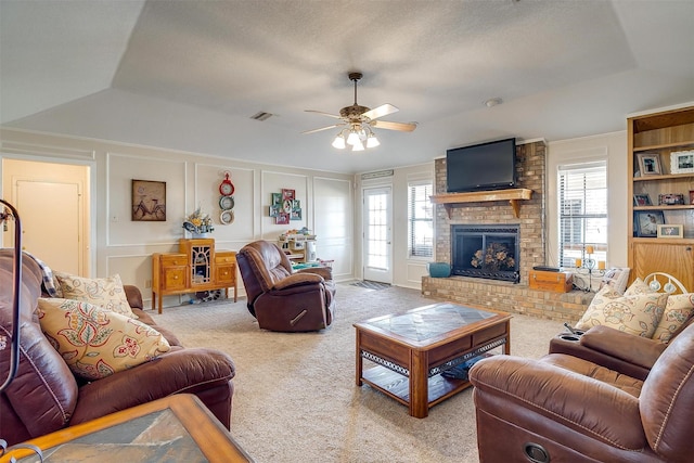 living area with carpet, a healthy amount of sunlight, visible vents, and a decorative wall