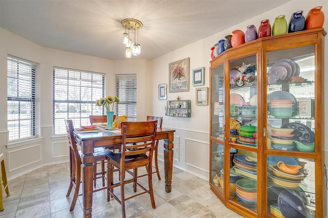 dining room featuring a wainscoted wall and a decorative wall