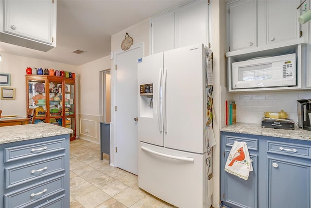 kitchen with white appliances, visible vents, light countertops, blue cabinetry, and tasteful backsplash