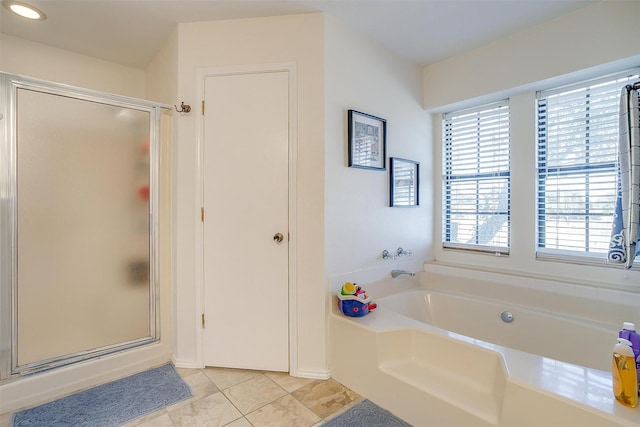 bathroom with a stall shower, a garden tub, and tile patterned floors