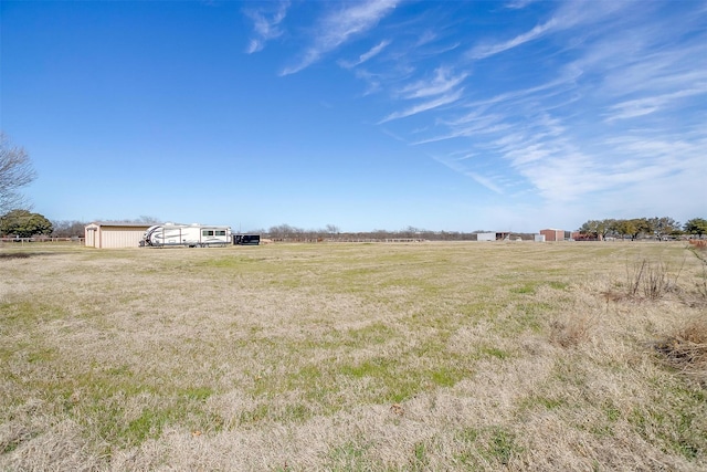 view of yard with an outbuilding and a rural view