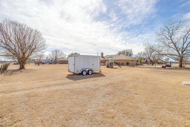 view of yard featuring a playground and fence