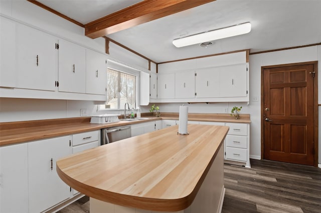 kitchen with butcher block countertops, dark wood-type flooring, stainless steel dishwasher, and white cabinetry