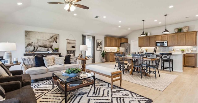 living area featuring lofted ceiling, recessed lighting, a ceiling fan, visible vents, and light wood-style floors