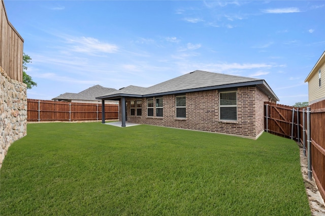 1825 Osage Trl, Mesquite, TX 75149 - back of property featuring roof with shingles, brick siding, and a patio