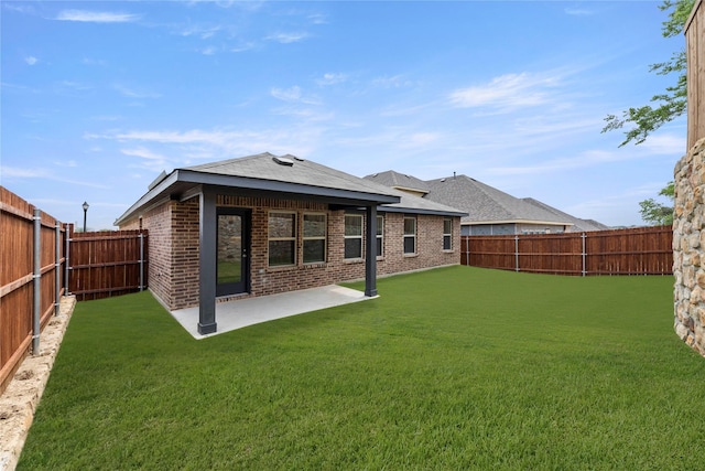 1825 Osage Trl, Mesquite, TX 75149 - back of property featuring a patio area, brick siding, and a shingled roof