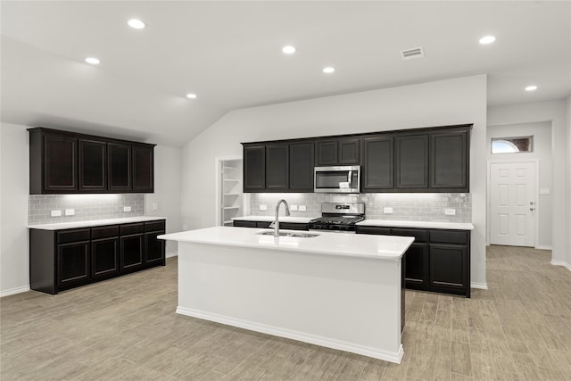 1825 Osage Trl, Mesquite, TX 75149 - kitchen with stainless steel appliances, a sink, backsplash, an island with sink, and light countertops