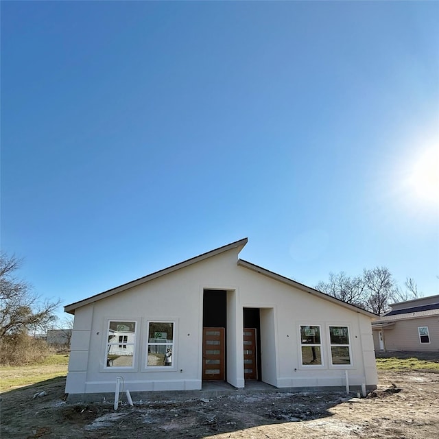 back of property with stucco siding and an outdoor structure