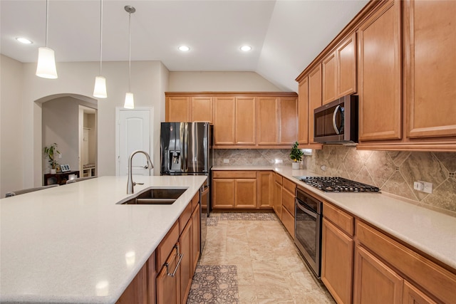 kitchen featuring arched walkways, stainless steel appliances, a sink, light countertops, and decorative backsplash