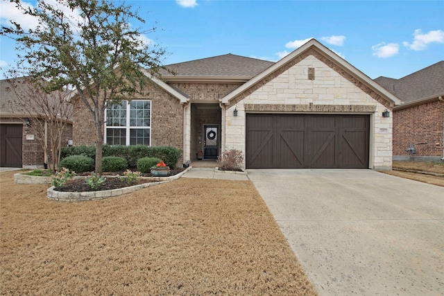 view of front of house with driveway, a shingled roof, stone siding, an attached garage, and a front lawn