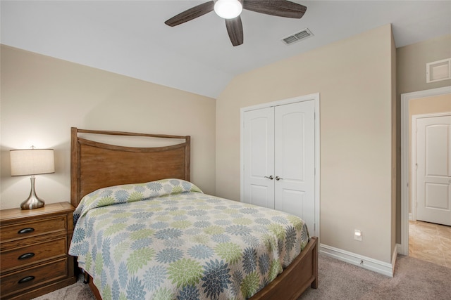 bedroom featuring light carpet, a closet, lofted ceiling, and visible vents