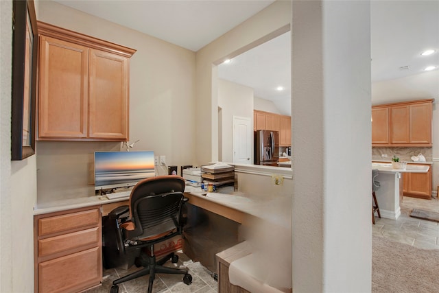 home office featuring recessed lighting, stone finish flooring, and built in desk