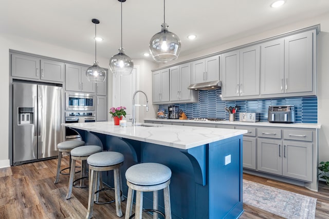 kitchen with stainless steel appliances, gray cabinets, a sink, and under cabinet range hood