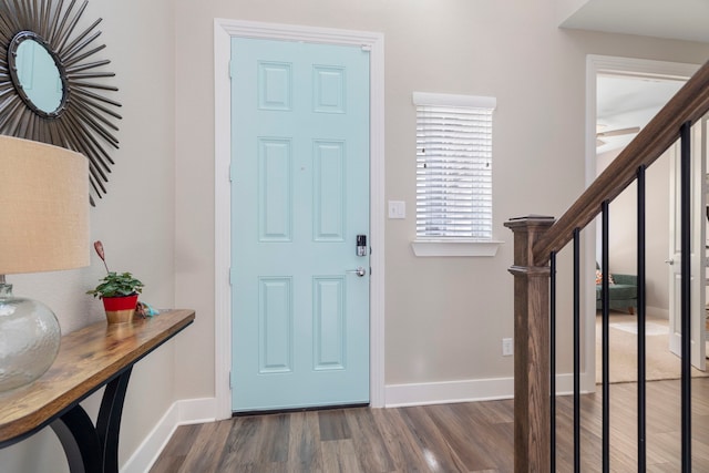 entrance foyer featuring stairs, baseboards, and dark wood-type flooring