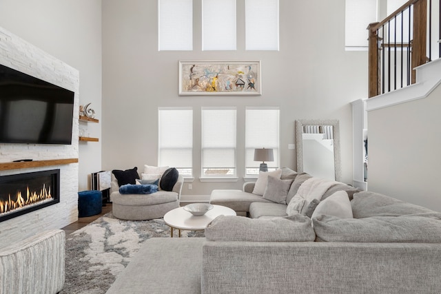 living room with a high ceiling, a fireplace, and wood finished floors