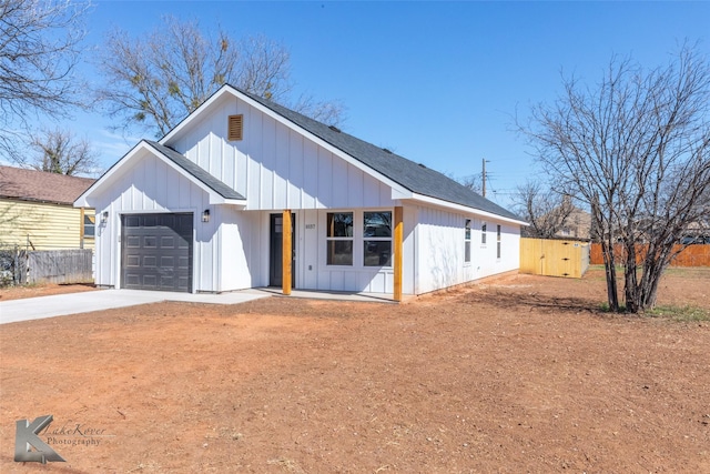 modern farmhouse featuring a garage, fence, driveway, roof with shingles, and board and batten siding