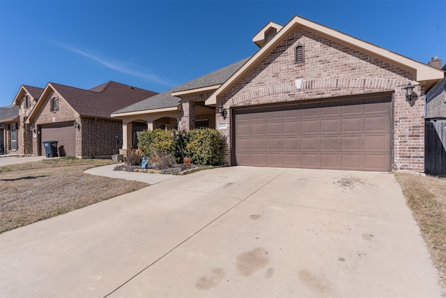 view of front of property featuring a garage, driveway, and brick siding