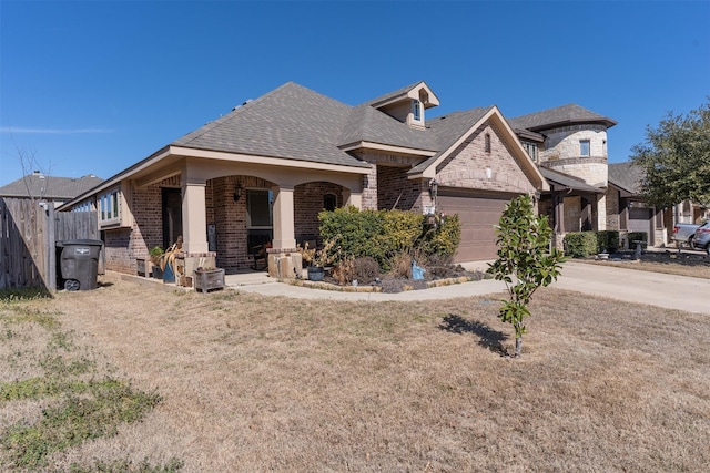 french country style house with brick siding, a shingled roof, a garage, driveway, and a front lawn